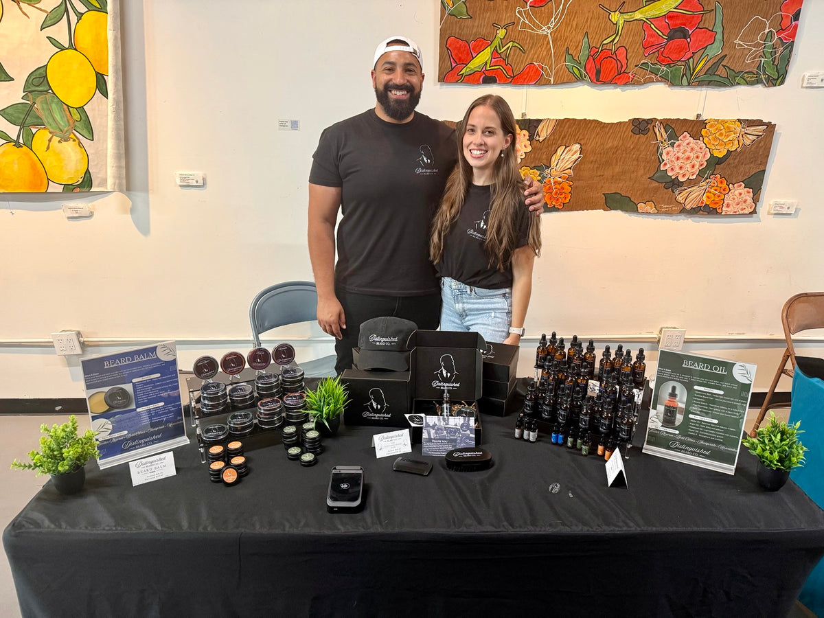 The Distinguished Beard Co. team together behind their beard care display at a local market.