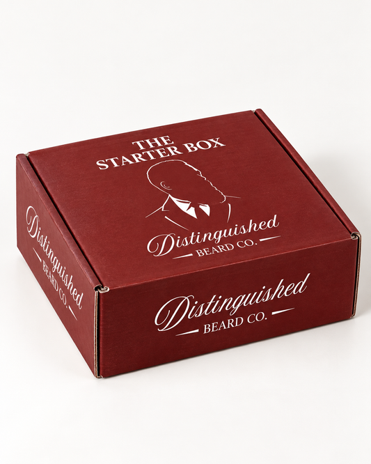 Distinguished Beard Co. deep-red Starter Box with white branding, photographed at a three-quarter angle